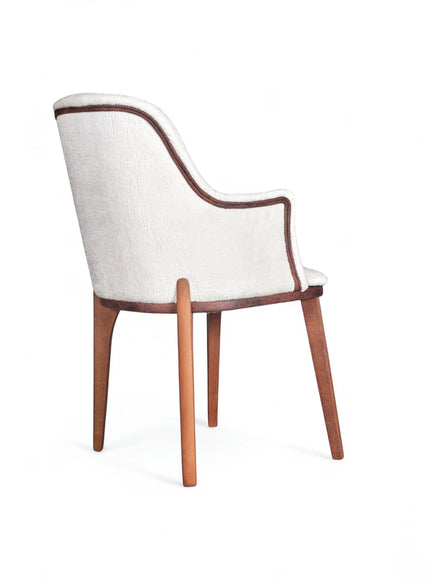 Rear angled view of the Vaya Home Cadena dining chair featuring white boucle upholstery, curved arms, and tapered wood legs.