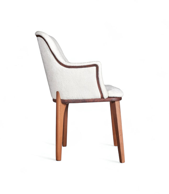 Side view of the Vaya Home Cadena dining chair with white boucle upholstery, curved arm detail, and tapered wood legs.