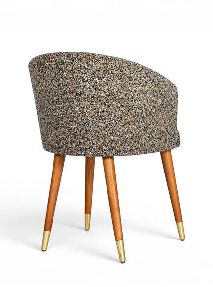 Back view of the Vaya Home Cambria accent chair with multitone textured upholstery, a rounded barrel back, and tapered wood legs with gold caps.
