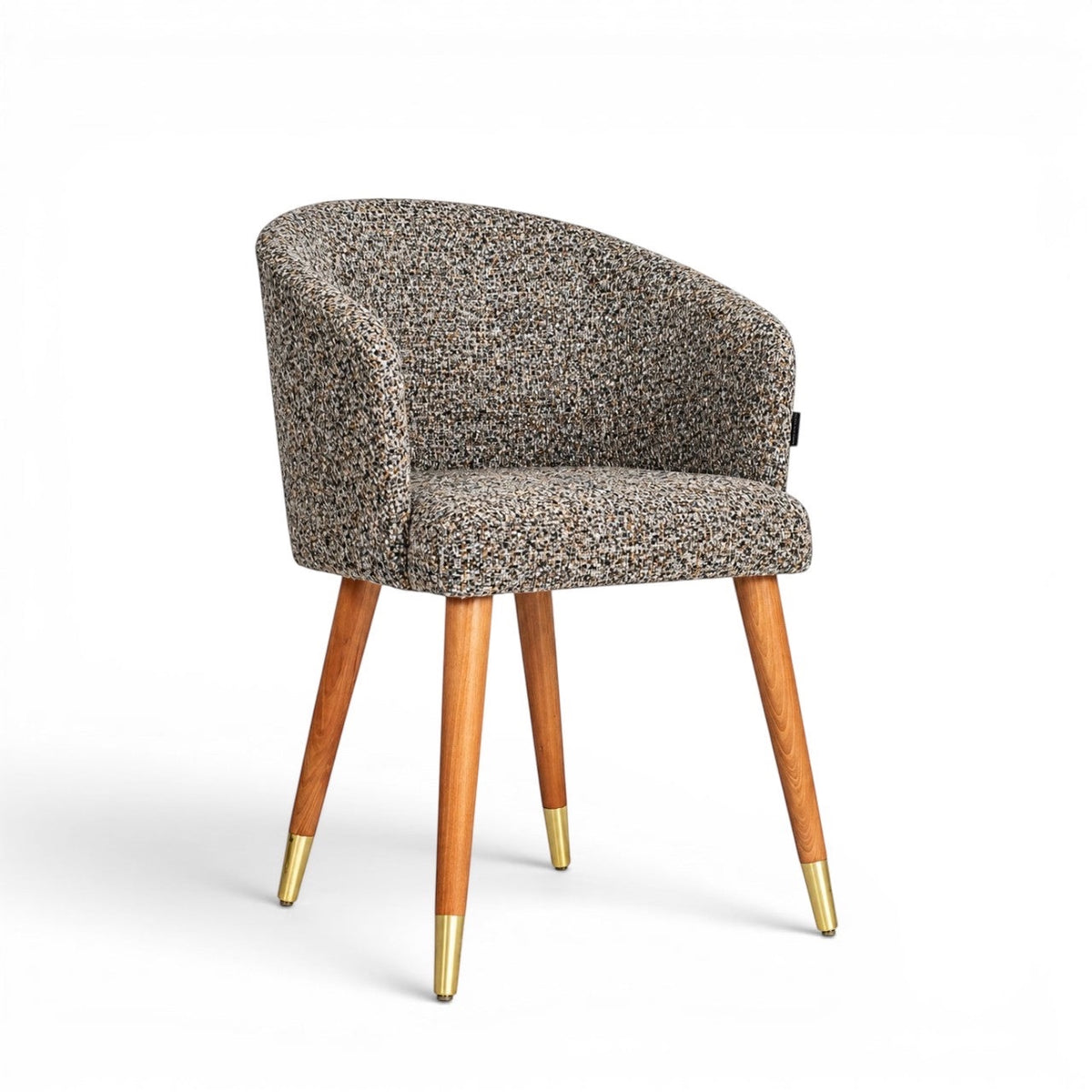 Front angled view of the Vaya Home Cambria accent chair with multitone textured upholstery, a rounded barrel back, and tapered wood legs with gold caps.