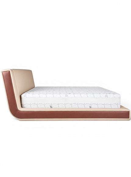 Side view of the Vaya Home Camelia bed featuring beige upholstery, a low platform frame, and warm brown side detailing.