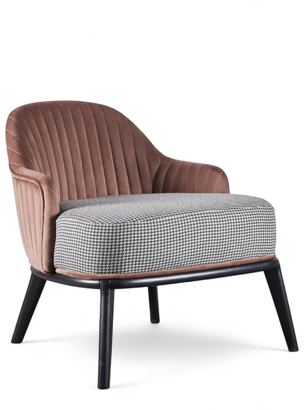 Front angled view of the Vaya Home Carruba accent chair with curved arms, a rose gold channel-tufted back, gray upholstered seat, and black legs.