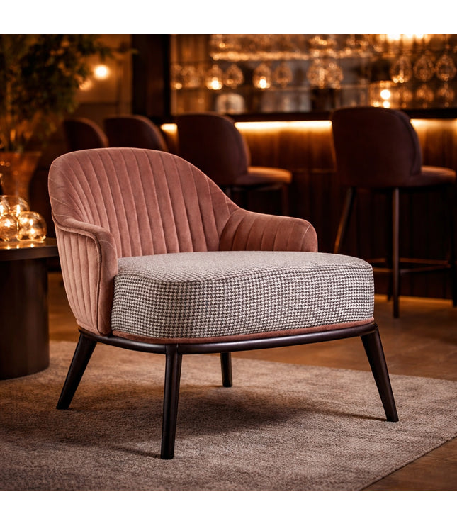 Vaya Home Carruba accent chair with a rose gold channel-tufted back, gray upholstered seat, and black legs, styled in a warm lounge setting.