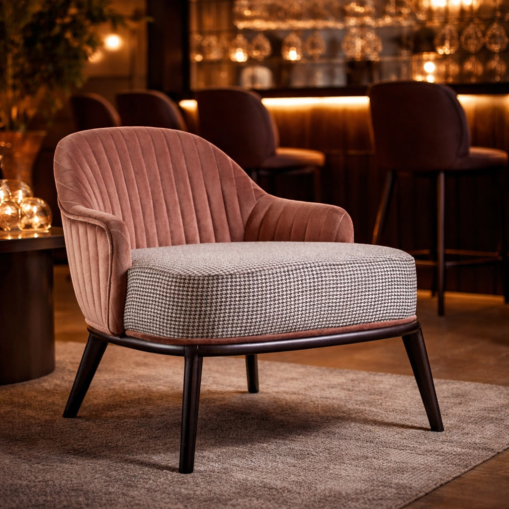 Vaya Home Carruba accent chair with a rose gold channel-tufted back, gray upholstered seat, and black legs, styled in a warm lounge setting.