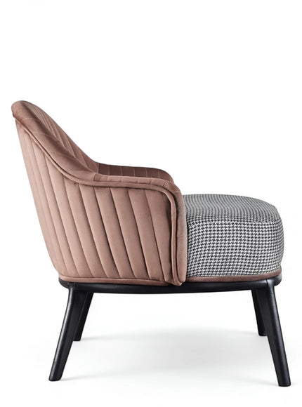 Side view of the Vaya Home Carruba accent chair featuring a rose gold channel-tufted back, gray upholstered seat, and black legs.