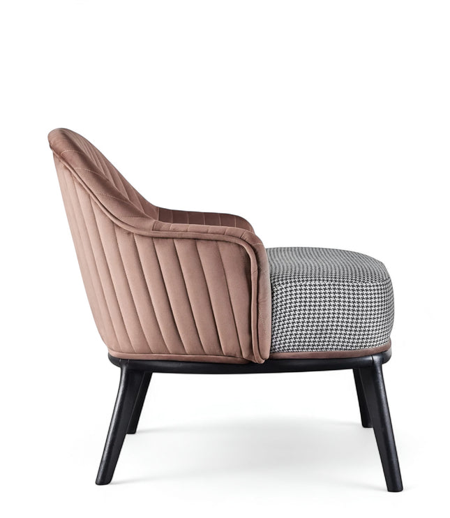 Side view of the Vaya Home Carruba accent chair featuring a rose gold channel-tufted back, gray upholstered seat, and black legs.