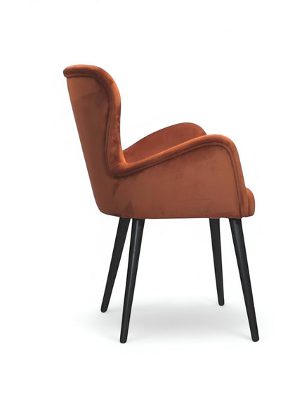Side view of the Vaya Home Celebrity accent chair with orange upholstery, sculpted arms, and black tapered legs.
