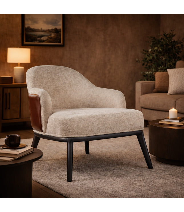 Vaya Home Chocolate accent chair with beige upholstery, brown leather outer back, and black legs, styled in a warm modern living room.