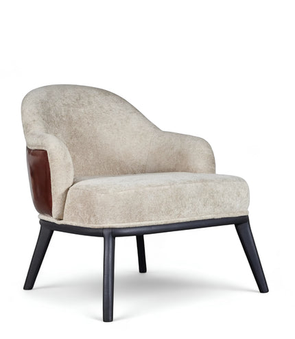 Front angled view of the Vaya Home Chocolate accent chair with beige upholstery, curved silhouette, brown leather side detail, and black legs.