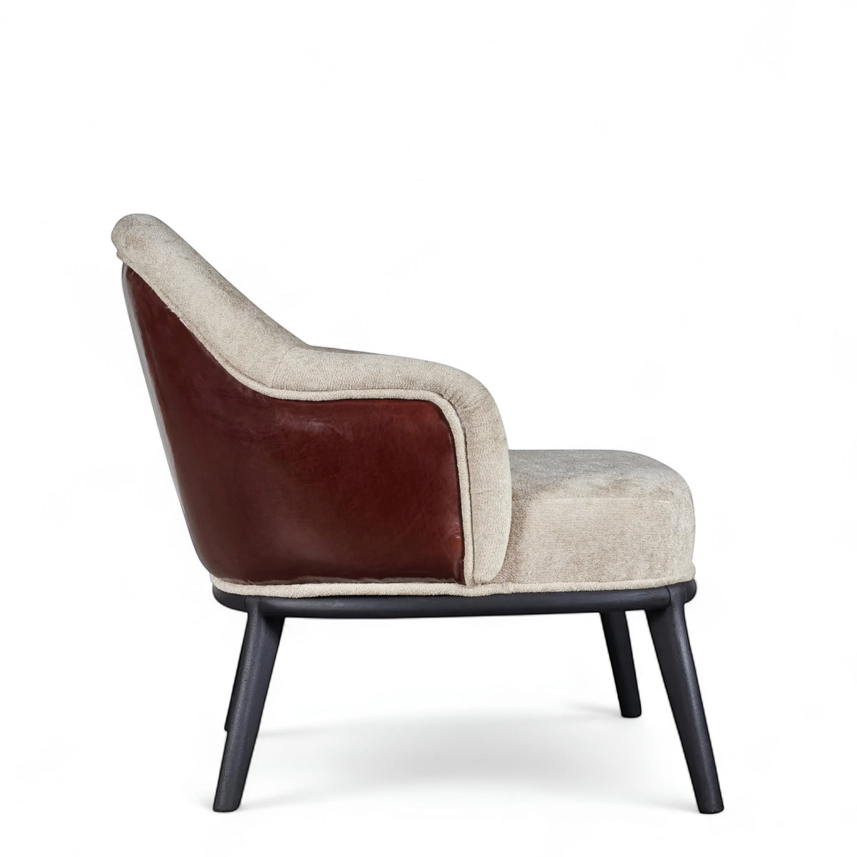 Side view of the Vaya Home Chocolate accent chair featuring beige upholstery, brown leather outer back, curved arms, and black legs.