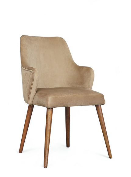 Front angled view of the Vaya Home Ciervo dining chair with beige upholstery, curved arm detail, and tapered wood legs.