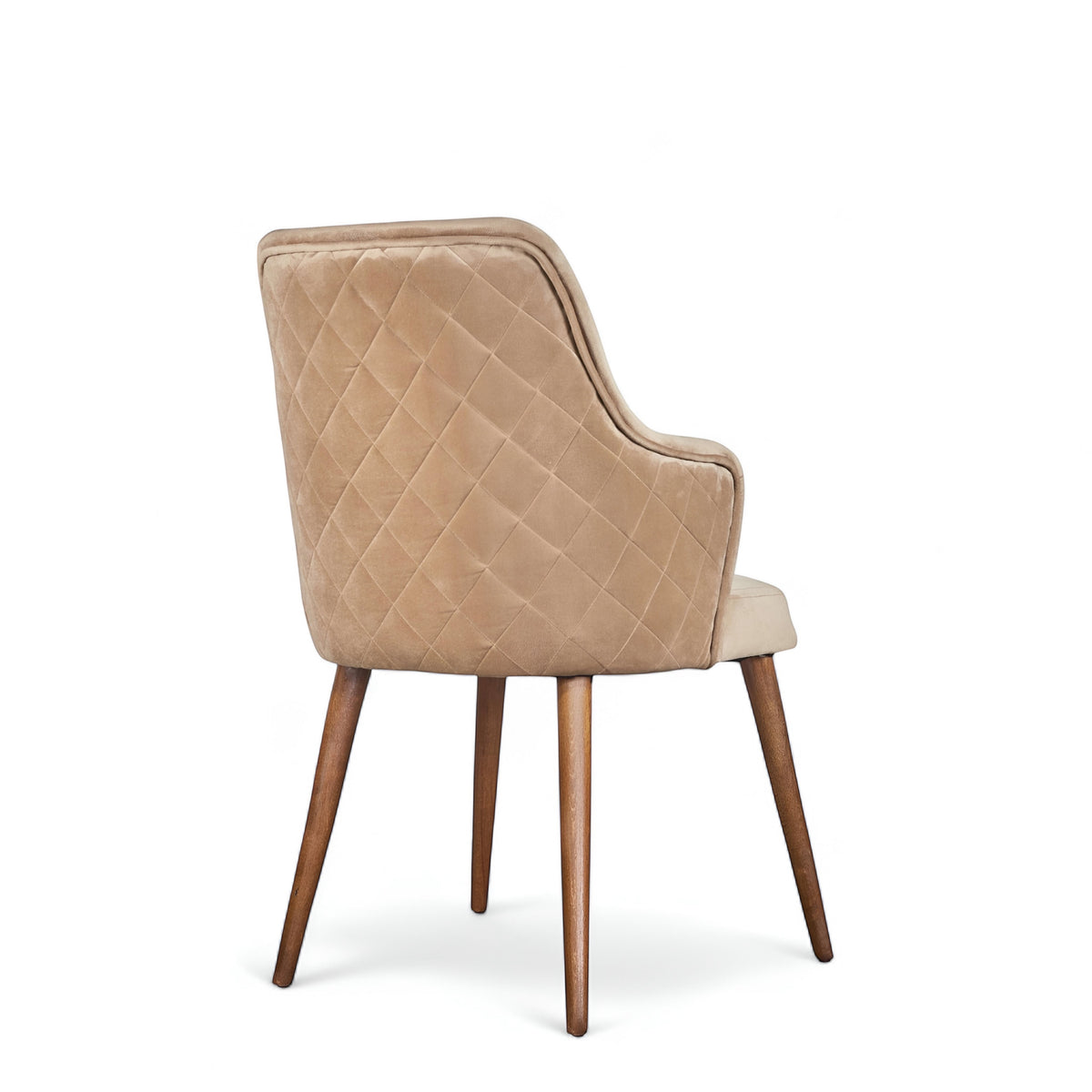 Rear angled view of the Vaya Home Ciervo dining chair featuring beige upholstery, diamond-quilted outer back, and tapered wood legs.