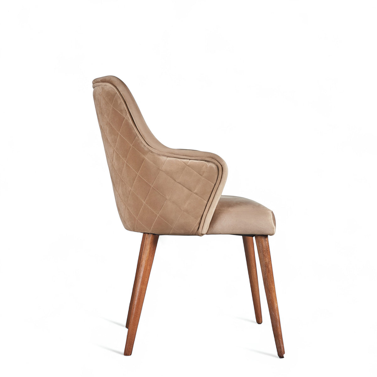 Side view of the Vaya Home Ciervo dining chair with beige upholstery, curved arms, and tapered wood legs.