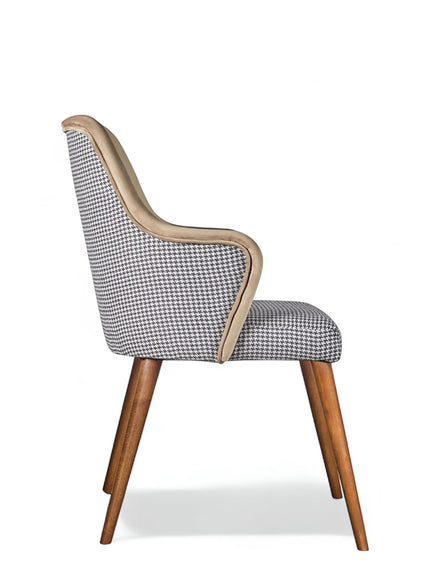 Side view of the Vaya Home Ciervo dining chair with houndstooth upholstery, curved arms, and tapered wood legs.