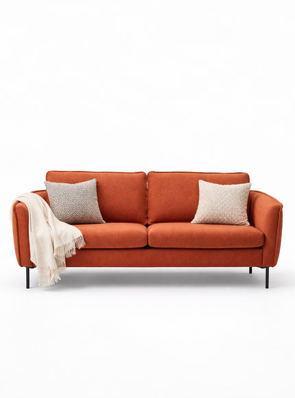 Front view of the Vaya Home Cobalt sofa with orange upholstery, slim arms, two seat cushions, and accent pillows.