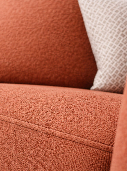 Close-up of the Vaya Home Cobalt sofa showing orange upholstery and textured seat cushion detail.