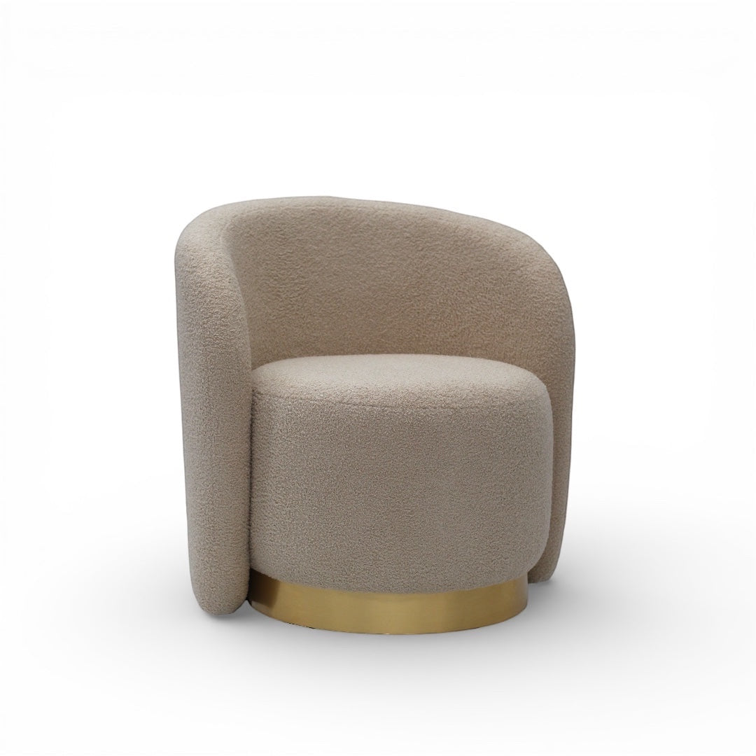 Angled front view of the Vaya Home Cocoon accent chair with beige boucle upholstery, curved silhouette, and gold base detail.