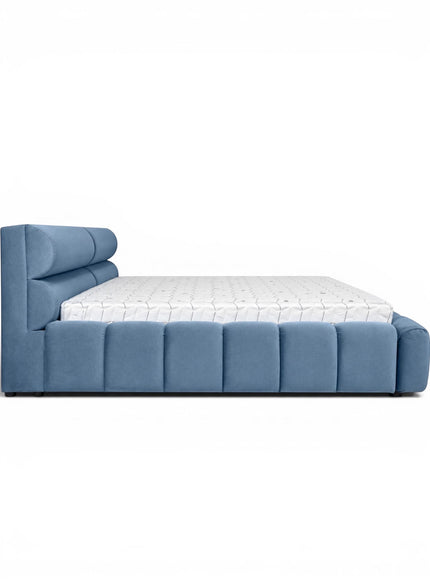 Side view of the Vaya Home Como upholstered platform bed featuring blue upholstery, a padded headboard, and a channel-detailed base.