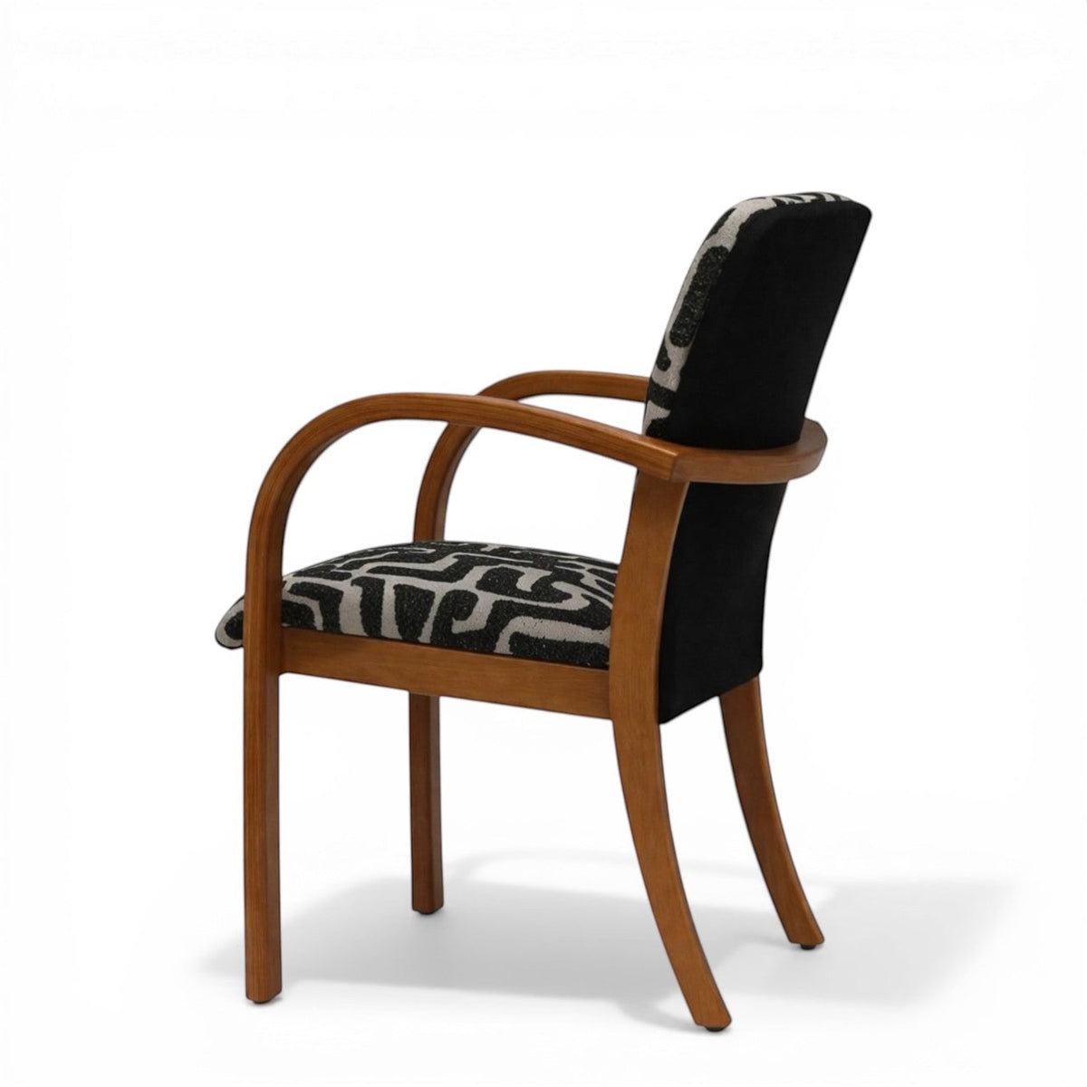 Angled back view of the Vaya Home Contour accent chair with curved wood frame, black rear upholstery panel, and patterned seat.