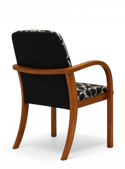 Back view of the Vaya Home Contour accent chair featuring a curved wood frame and solid black upholstered back panel.