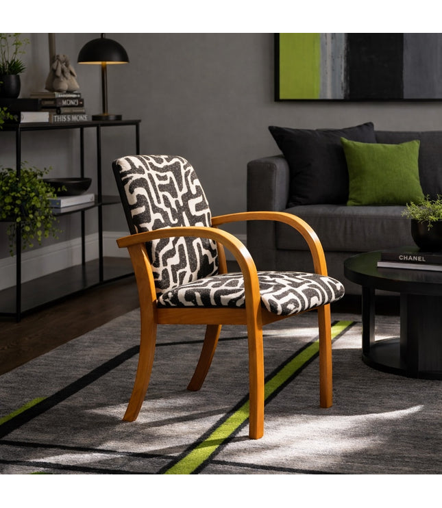 Vaya Home Contour accent chair with curved wood arms and black-and-cream abstract patterned upholstery, styled in a modern living room.