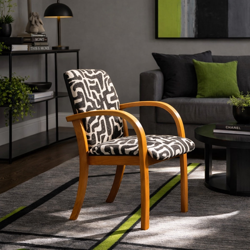 Vaya Home Contour accent chair with curved wood arms and black-and-cream abstract patterned upholstery, styled in a modern living room.