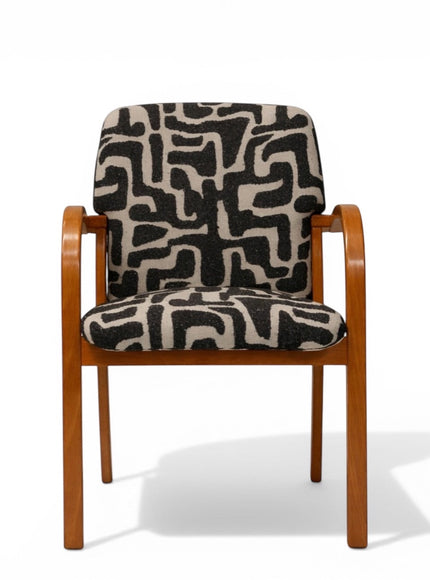 Front view of the Vaya Home Contour accent chair with curved wood frame and black-and-cream abstract patterned seat and back upholstery.