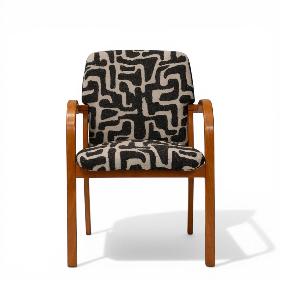 Front view of the Vaya Home Contour accent chair with curved wood frame and black-and-cream abstract patterned seat and back upholstery.