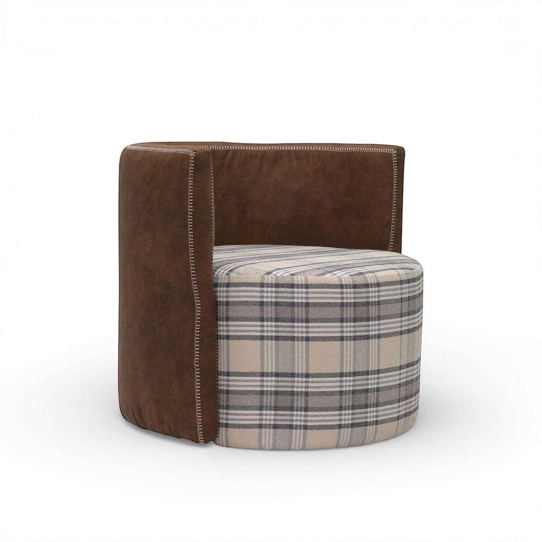 Side angled view of the Vaya Home Corvyn armchair showing a checkered upholstered seat and curved brown leather outer frame.
