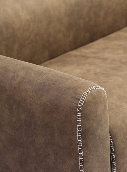 Close-up of the Vaya Home Corvyn sofa showing brown leather upholstery, curved arm detail, and contrast stitching.