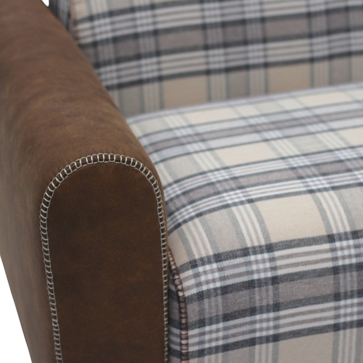 Close-up of the Vaya Home Corvyn sofa showing checkered upholstery and brown leather arm detail.