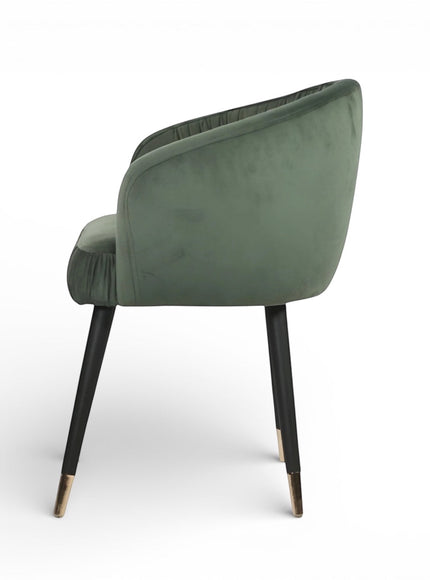 Side view of the Vaya Home Cushion accent chair with green velvet upholstery and black legs with gold caps.
