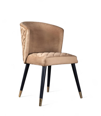 Front angled view of the Vaya Home Diamante dining chair with beige upholstery, cushioned seat, and black tapered legs with gold caps.