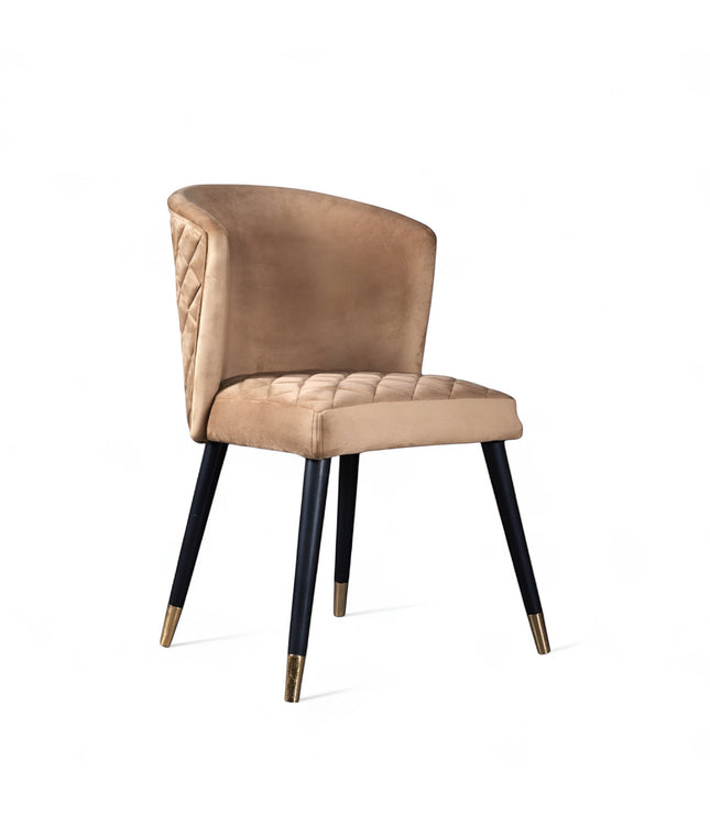 Front angled view of the Vaya Home Diamante dining chair with beige upholstery, cushioned seat, and black tapered legs with gold caps.