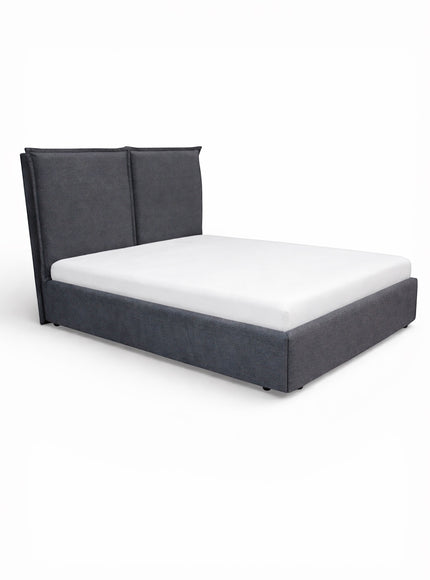Side angled view of the Vaya Home Elmon upholstered bed with grey fabric upholstery and a two-panel headboard.
