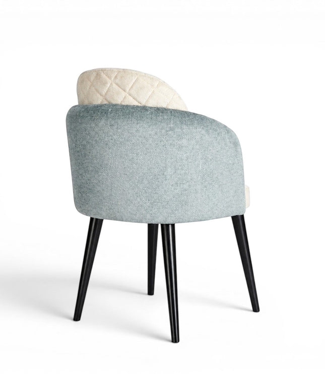 Back view of the Vaya Home Elowen dining chair featuring a blue upholstered outer back, cream inner upholstery, and black legs.