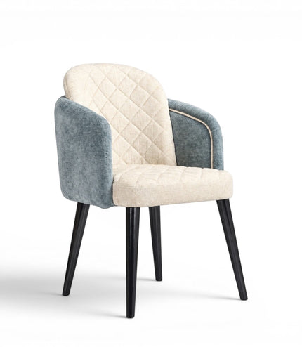 Front angled view of the Vaya Home Elowen dining chair with a cream diamond-tufted inner back, blue upholstered outer back and arms, and black legs.