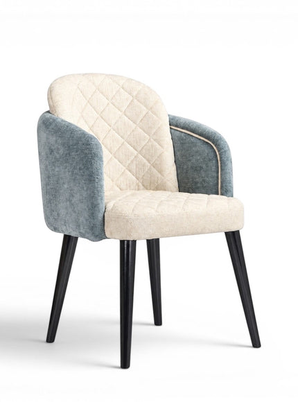 Front angled view of the Vaya Home Elowen dining chair with a cream diamond-tufted inner back, blue upholstered outer back and arms, and black legs.