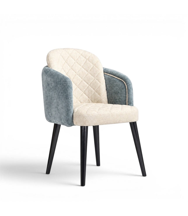 Front angled view of the Vaya Home Elowen dining chair with a cream diamond-tufted inner back, blue upholstered outer back and arms, and black legs.