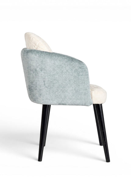 Rear angled view of the Vaya Home Elowen dining chair with blue upholstered outer back and arms, cream seat and back panel, and black legs.