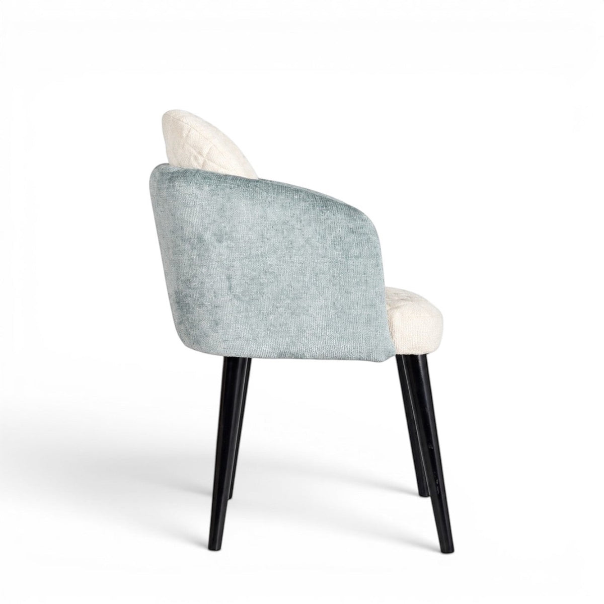 Rear angled view of the Vaya Home Elowen dining chair with blue upholstered outer back and arms, cream seat and back panel, and black legs.