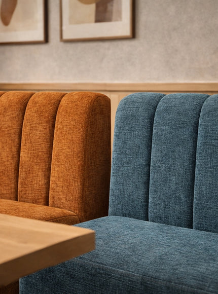 Vaya Home Elteo bench sofa in orange and blue upholstery with channel-tufted backs, styled in a modern dining setting.
