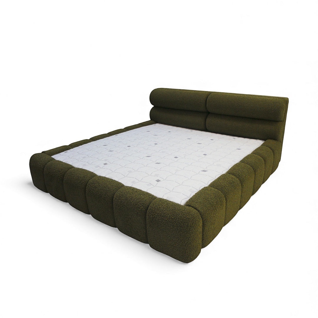 Side angled view of the Vaya Home Forma bed with olive green upholstery and sculpted padded frame detail.