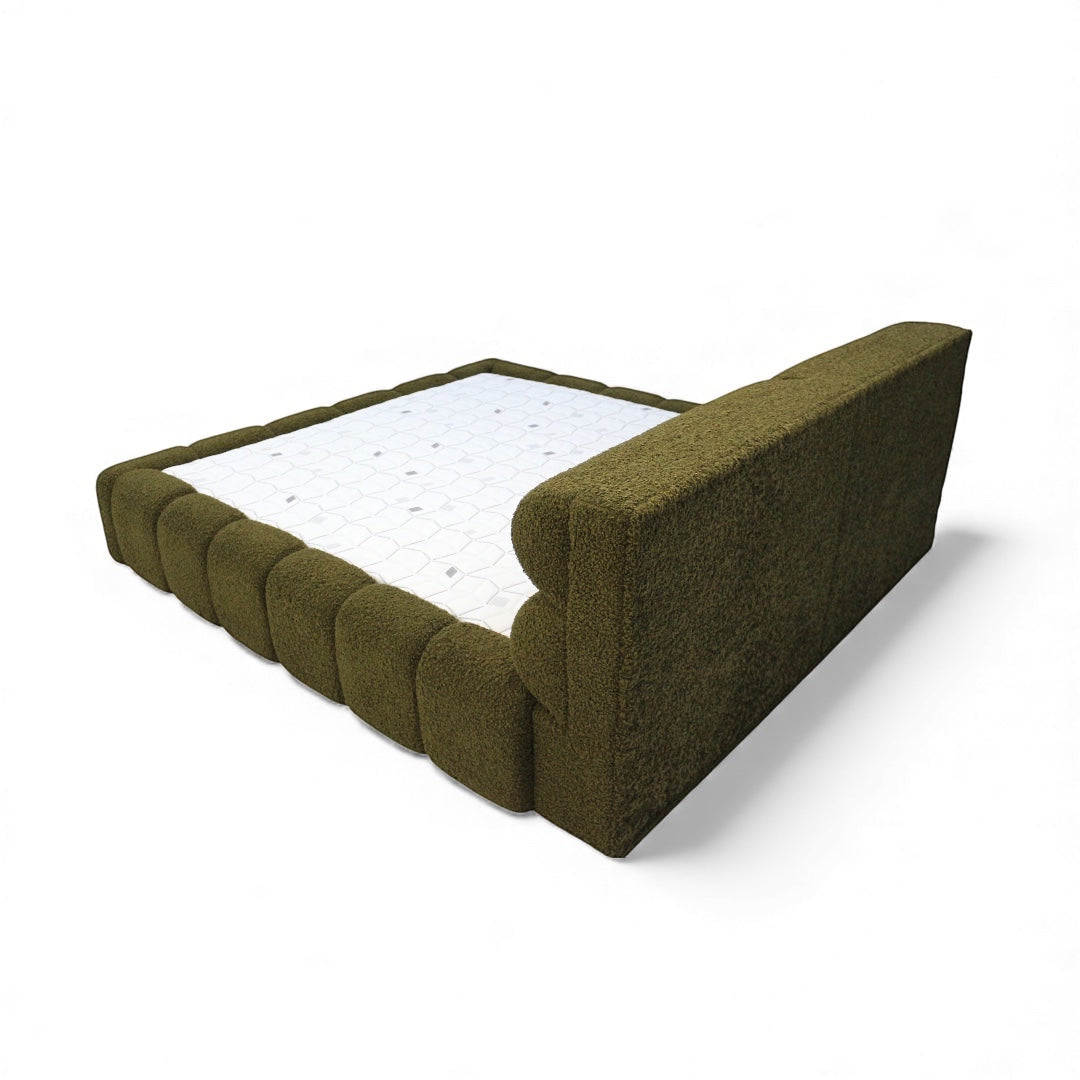 Rear angled view of the Vaya Home Forma bed showing the upholstered headboard and padded olive green frame.