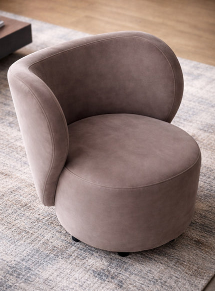 Angled view of the Vaya Home Halo accent chair with taupe upholstery, rounded seat, and sculptural curved backrest.