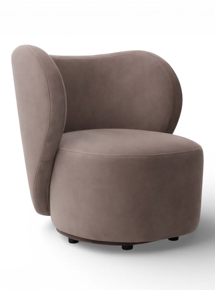 Side view of the Vaya Home Halo accent chair showing its sculptural silhouette, curved back panel, and taupe upholstery.