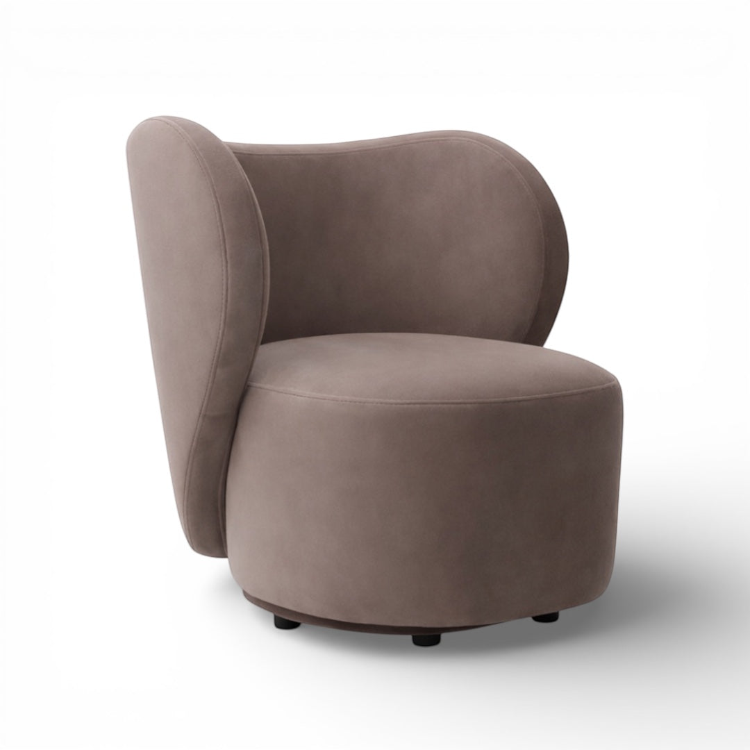 Side view of the Vaya Home Halo accent chair showing its sculptural silhouette, curved back panel, and taupe upholstery.