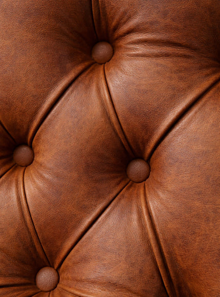 Close-up of the Vaya Home Hudson dining chair showing brown faux leather upholstery and button-tufted detailing.