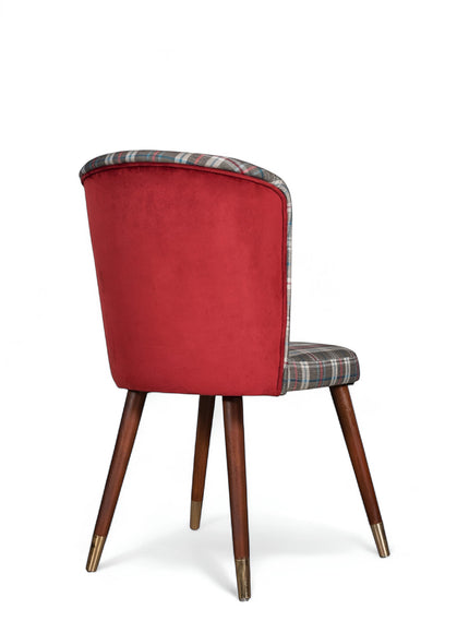 Rear angled view of the Vaya Home Inverto dining chair featuring a red upholstered back, checkered seat and front panel, and wood legs with gold caps.