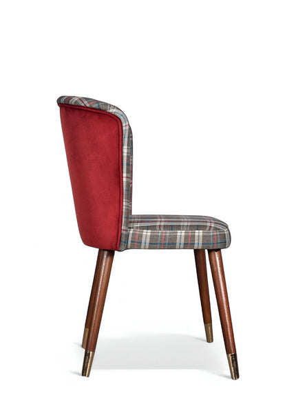 Side view of the Vaya Home Inverto dining chair with checkered upholstery, red outer back, and tapered wood legs with gold caps.